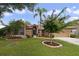 Tan house with landscaped yard, palm tree, and two-car garage at 3084 Heartleaf Pl, Winter Park, FL 32792