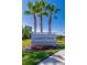 Coastal Woods community sign with palm trees and vibrant flowers enhances curb appeal at 3191 Crab Trap Dr, New Smyrna Beach, FL 32168