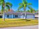 Light blue house with palm trees and driveway at 3220 Tamarind Dr, Edgewater, FL 32141