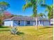 Light blue house with a two-car garage and palm trees at 3220 Tamarind Dr, Edgewater, FL 32141