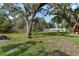 Large backyard with mature oak trees and a home in the background at 384 W Ariel Rd, Edgewater, FL 32141