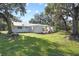 White home with a green metal roof and lush landscaping at 384 W Ariel Rd, Edgewater, FL 32141