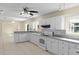 White kitchen cabinets, gray countertops and tile floors, open to dining area at 384 W Ariel Rd, Edgewater, FL 32141