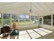 Bright sunroom with tiled floor, view of backyard, and ceiling fan at 384 W Ariel Rd, Edgewater, FL 32141