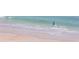 Person walking into the ocean on a sandy beach at 3851 S Atlantic Ave # 701, Daytona Beach Shores, FL 32118