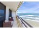 Balcony with partial ocean view and wicker chairs at 3855 S Atlantic Ave # 1105, Daytona Beach Shores, FL 32118