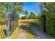 Long driveway leading to a home with a black metal gate at 4045 Jason St, New Smyrna Beach, FL 32168