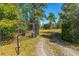 Gated entrance to a private property with a long gravel driveway at 4045 Jason St, New Smyrna Beach, FL 32168