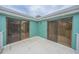 Spacious balcony with glass sliding doors and teal walls at 4150 S Atlantic Ave # 112C, New Smyrna Beach, FL 32169