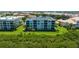 Exterior view of a well-maintained condo building surrounded by palm trees and green space at 432 Bouchelle Dr # 403, New Smyrna Beach, FL 32169