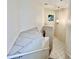 White tiled staircase with a small window and chandelier at 439 Bouchelle Dr # 202, New Smyrna Beach, FL 32169