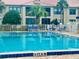 Community pool with patio furniture and building view at 439 Bouchelle Dr # 202, New Smyrna Beach, FL 32169