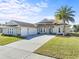 Beautiful tan house with three-car garage and palm tree at 508 Campana St, New Smyrna Beach, FL 32168