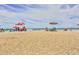 Beachfront view with umbrellas and people enjoying a sunny day at 5300 S Atlantic Ave # 9-507, New Smyrna Beach, FL 32169