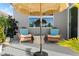 Relaxing outdoor seating area with comfortable chairs and a sun umbrella on a serene patio at 5340 Bear Corn Run, Port Orange, FL 32128