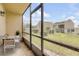 Enclosed balcony features a view of the lawn, pool, and surrounding buildings from a table with chairs at 632 Sausalito Blvd, Casselberry, FL 32707