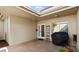 Enclosed patio featuring brick pavers, a grill covered for storage and an exterior door leading to the rest of the property at 632 Sausalito Blvd, Casselberry, FL 32707