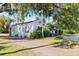 Side view of a charming light blue house nestled amongst lush greenery at 636 Faulkner St, New Smyrna Beach, FL 32168