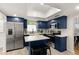 Modern kitchen with blue cabinetry, island, and stainless steel appliances at 636 Faulkner St, New Smyrna Beach, FL 32168