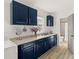 Laundry room with navy blue cabinets, sink, and adjacent bathroom at 636 Faulkner St, New Smyrna Beach, FL 32168