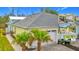 Bright yellow house with gray roof, white garage door, and palm trees in the front at 667 Margaritaville Ave, Daytona Beach, FL 32124