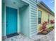 Charming teal front door and walkway leading to a light blue home at 667 Margaritaville Ave, Daytona Beach, FL 32124