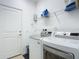 Bright laundry room with washer, dryer, and overhead shelving at 667 Margaritaville Ave, Daytona Beach, FL 32124