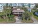 Aerial view of beach house with large deck and tropical landscaping at 6911 Turtlemound Rd, New Smyrna Beach, FL 32169