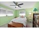 Charming bedroom with light green walls, ceiling fan, and ample storage at 705 Wayne Ave, New Smyrna Beach, FL 32168