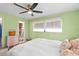 Main bedroom with light green walls, ceiling fan, and walk-in closet at 705 Wayne Ave, New Smyrna Beach, FL 32168