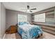 Bedroom with blue bedding, wood accent wall, and ceiling fan at 705 Wayne Ave, New Smyrna Beach, FL 32168