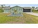 Landscaped front yard with a green house and a stone garden at 705 Wayne Ave, New Smyrna Beach, FL 32168