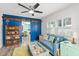 Cozy living room with blue sofa, wood shelving, and large windows at 705 Wayne Ave, New Smyrna Beach, FL 32168