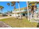 Two-story house with garage, palm trees, and white fence at 708 Ocean Ave, New Smyrna Beach, FL 32169