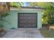 Dark brown garage door and light green house at 729 N Flamingo Dr, Daytona Beach, FL 32117