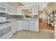 Modern kitchen with white cabinets, granite countertops, and a view into the living area at 813 Pine Shores Cir, New Smyrna Beach, FL 32168