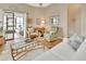 Living room with hardwood floors, white couch, wicker chairs, and screened porch access at 813 Pine Shores Cir, New Smyrna Beach, FL 32168