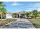Single-story home with tile roof, palm trees, and a brick driveway at 987 Mori Ct, Port Orange, FL 32127