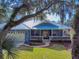 Blue house with metal roof, two-car garage, and landscaping at 1004 Flying M Ct, Edgewater, FL 32132