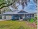 Charming blue house with a metal roof, two-car garage, and a spacious front porch at 1004 Flying M Ct, Edgewater, FL 32132