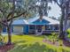 Blue house with metal roof, two-car garage, and landscaping at 1004 Flying M Ct, Edgewater, FL 32132