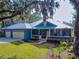 Blue house with metal roof, two-car garage, and landscaping at 1004 Flying M Ct, Edgewater, FL 32132