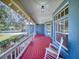 Inviting front porch with rocking chair and red floor at 1004 Flying M Ct, Edgewater, FL 32132