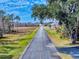 Long paved road with yellow line, trees and open field at 1004 Flying M Ct, Edgewater, FL 32132