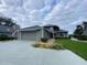 Gray house with attached garage, stone walkway, and landscaped lawn at 1104 Red Maple Way, New Smyrna Beach, FL 32168