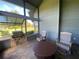 Screened porch with stone flooring, built in grill, and rocking chairs at 1104 Red Maple Way, New Smyrna Beach, FL 32168