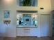 Home bar with glass shelving and built in sink at 1104 Red Maple Way, New Smyrna Beach, FL 32168