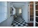 Checkerboard floor hallway connects rooms with built-in shelving and natural light at 1116 Magnolia St, New Smyrna Beach, FL 32168