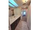 Bright bathroom with a long vanity, skylights and a doorway that leads to the bedroom at 113 Lagoon Ct, New Smyrna Beach, FL 32169