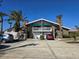 Inviting two-story home features a double garage, balcony, and tropical landscaping on a sunny day at 113 Lagoon Ct, New Smyrna Beach, FL 32169